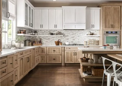 A kitchen with white cabinets and wooden floors.